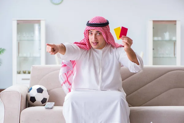 Arab man watching sport football at tv