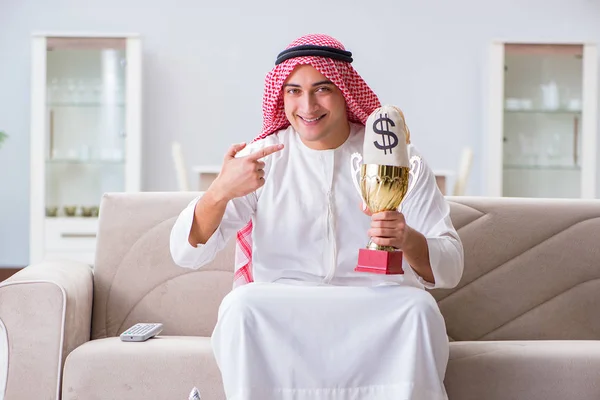 アラブ人男とともに賞とお金でソファ — ストック写真