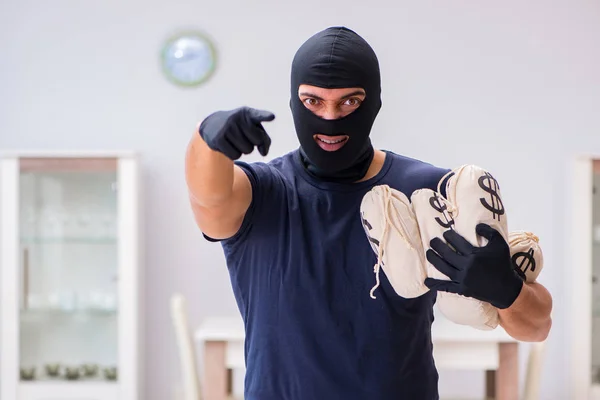 Ladrão usando balaclava roubando coisas valiosas — Fotografia de Stock