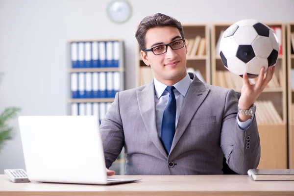 Empresário com bola de futebol no escritório — Fotografia de Stock