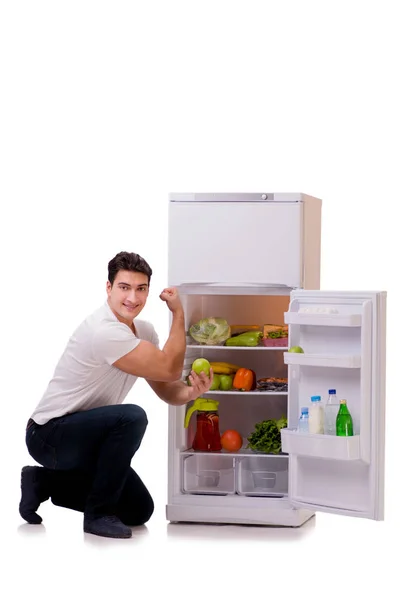 Homem ao lado do frigorífico cheio de comida — Fotografia de Stock