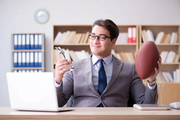 Empresario con fútbol americano en la oficina —  Fotos de Stock