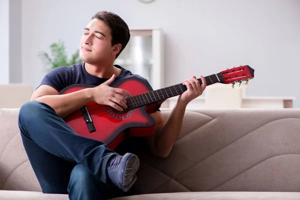 家でギターを練習してる若い男 — ストック写真