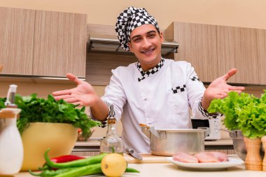 Genç aşçı mutfakta çalışıyor.