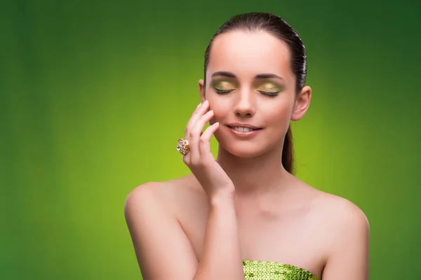 Mujer joven en concepto de belleza sobre fondo verde — Foto de Stock