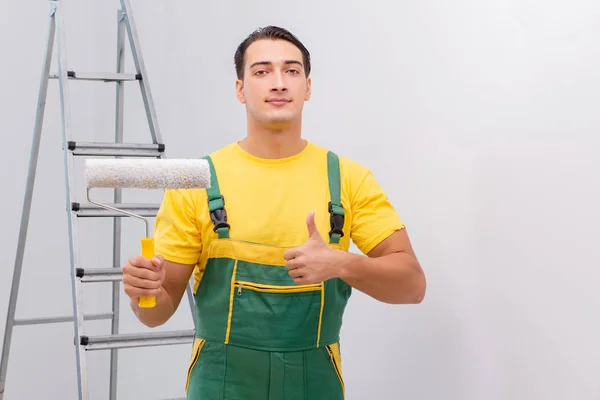 Uomo che dipinge il muro nel concetto di fai da te — Foto Stock