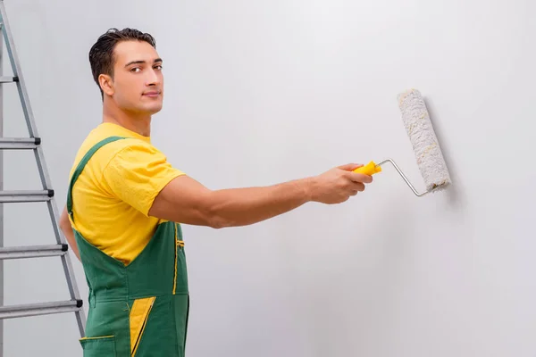 Uomo che dipinge il muro nel concetto di fai da te — Foto Stock