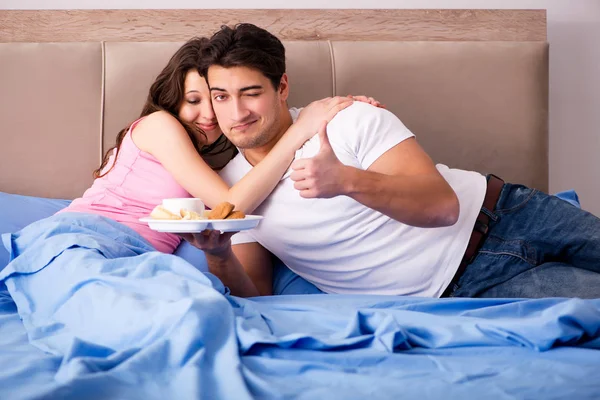 Lycklig familj som äter frukost på sängen — Stockfoto