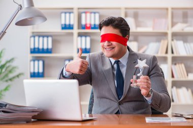 Ofiste masasında oturan gözü bağlı iş adamı.