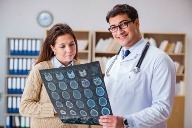 Genç doktor bilgisayardaki röntgen görüntülerine bakıyor.