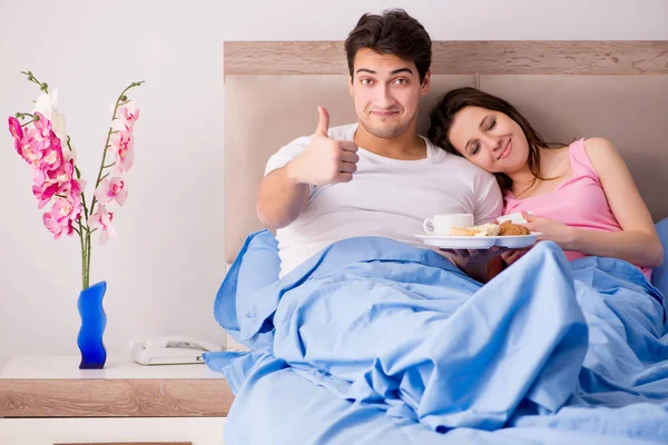 Familia feliz desayunando en la cama — Foto de Stock