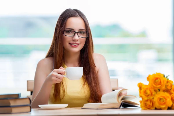 Jovem estudante bebendo café enquanto subitamente — Fotografia de Stock