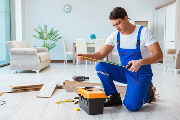 Reparador que estabelece piso laminado em casa — Fotografia de Stock