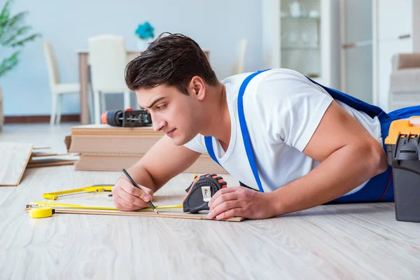 Reparador que estabelece piso laminado em casa — Fotografia de Stock