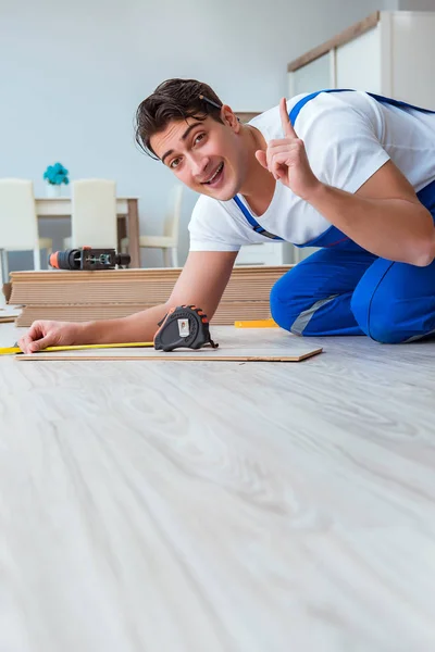 Reparador que estabelece piso laminado em casa — Fotografia de Stock