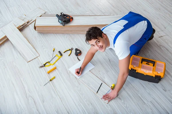 Reparador que estabelece piso laminado em casa — Fotografia de Stock