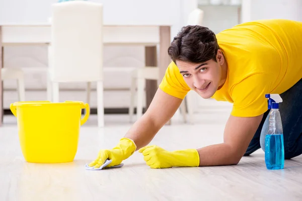 A férfi takarítja a házat, segít a feleségének. — Stock Fotó