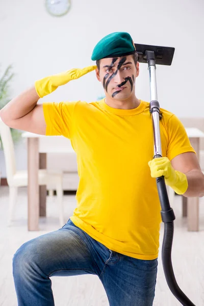 Funny man in military style cleaning the house — Stock Photo, Image