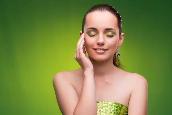 Mladá žena v pojetí krásy na zeleném pozadí — Stock fotografie