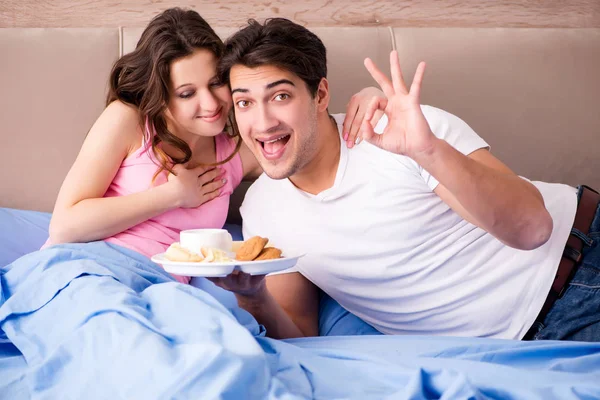 Família feliz tomando café da manhã na cama — Fotografia de Stock