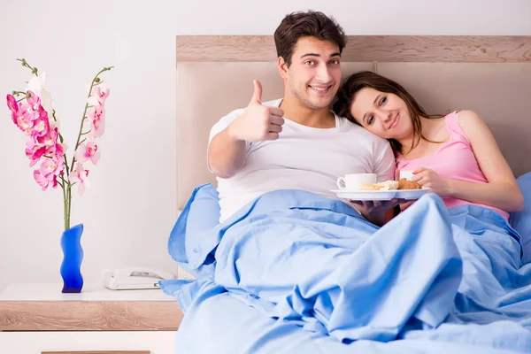 Família feliz tomando café da manhã na cama — Fotografia de Stock