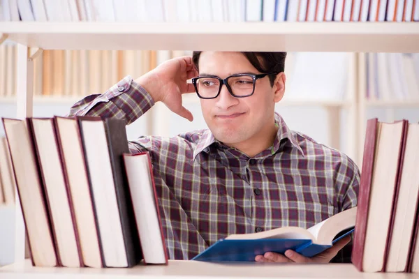 Jovem estudante procurando livros na biblioteca da faculdade — Fotografia de Stock