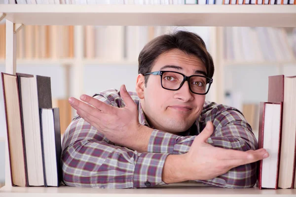 Jonge student op zoek naar boeken in universiteitsbibliotheek — Stockfoto