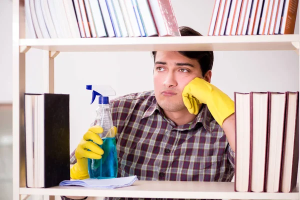 Man cleaning dust from bookshelf