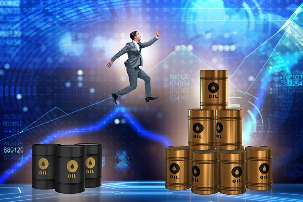 Бизнесмен прыгает со стопки нефтяных баррелей — стоковое фото