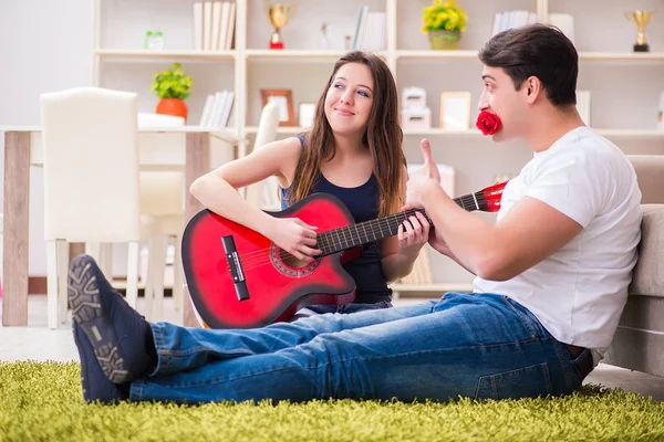 Pareja romántica tocando la guitarra en el suelo — Foto de Stock