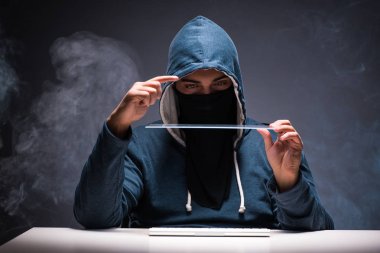 Bilgisayar korsanı karanlık odada çalışıyor.