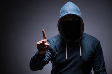 Karanlık odada kaputu giyen adam