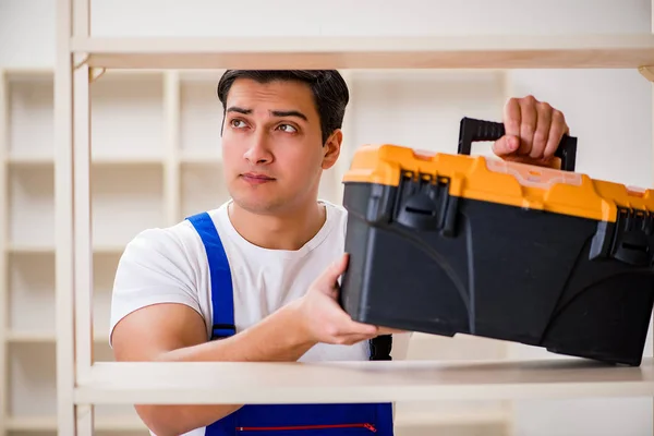 Trabalhador reparando montagem estante de livros — Fotografia de Stock