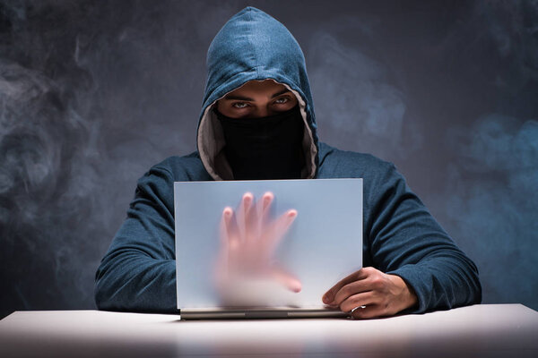 Computer hacker working in dark room
