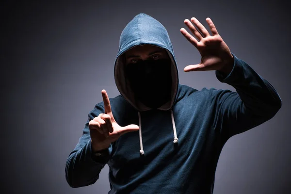 Man wearing hood in dark room — Stock Photo, Image