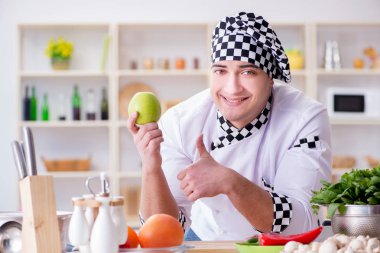 Genç aşçı mutfakta çalışıyor.