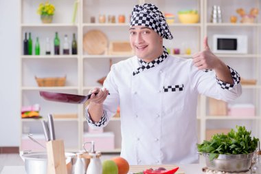 Genç aşçı mutfakta çalışıyor.