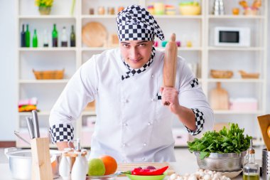 Genç aşçı mutfakta çalışıyor.