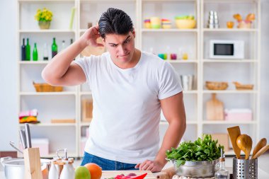 Genç aşçı mutfakta çalışıyor.