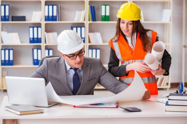 İnşaat ustabaşı çizimleri gözden geçiriyor