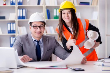 İnşaat ustabaşı çizimleri gözden geçiriyor