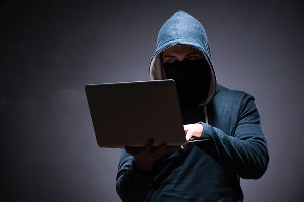 Hacker wearing hood in dark room — Stock Photo, Image