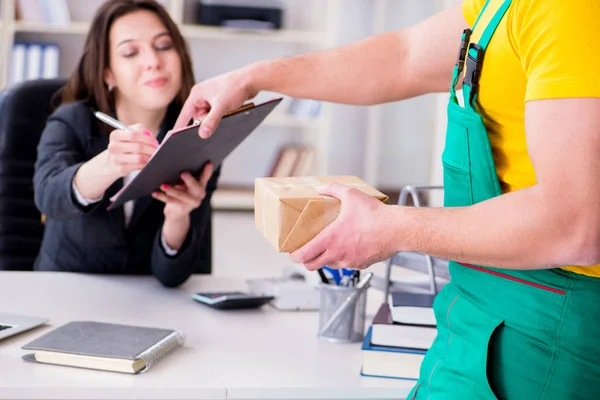 Postbode bezorgt pakketje op kantoor — Stockfoto