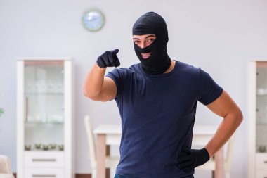 Soyguncu kar maskesi takıp değerli şeyler çalıyor.