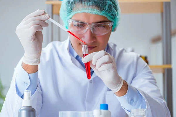 Jonge arts werkt aan bloedonderzoek in het lab ziekenhuis — Stockfoto