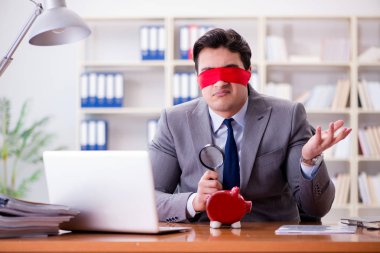 Ofiste masasında oturan gözü bağlı iş adamı.