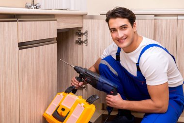 Mutfakta çalışan genç tamirci.