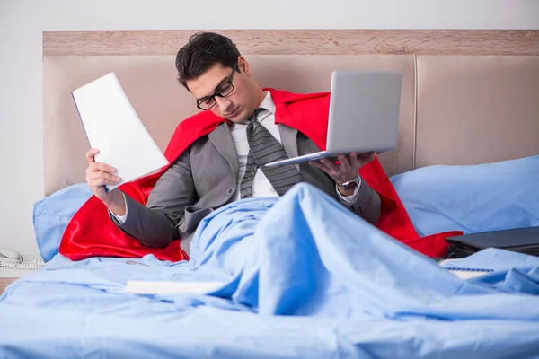 Super hero businesswoman working in bed — Stock Photo, Image