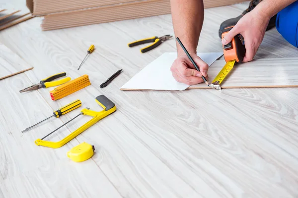 Reparador que estabelece piso laminado em casa — Fotografia de Stock