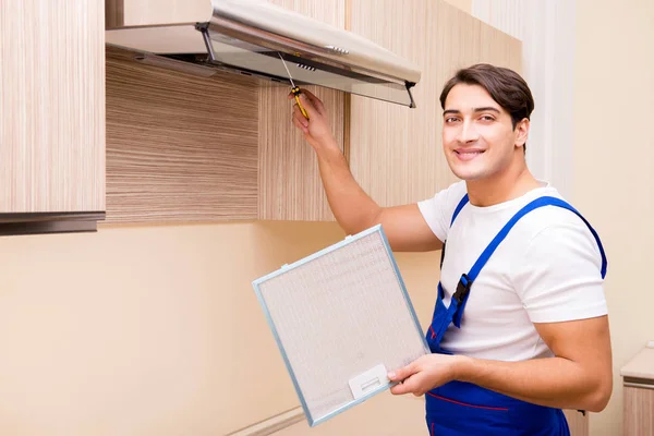 A fiatalember konyhai felszereléssel dolgozik. — Stock Fotó